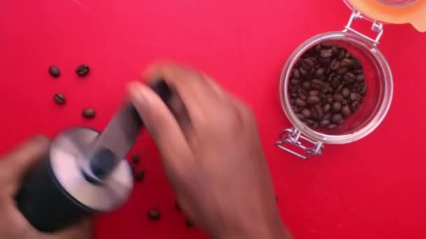 在红色背景上人工研磨咖啡豆的人的平铺 — 图库视频影像
