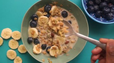 Düz manzaralı kişi müsli gevreğini meyvelerle hazırlıyor.