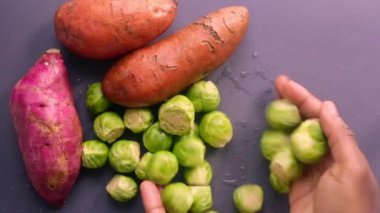 90 derece manzaralı şef tatlı patates ve Brüksel lahanası hazırlıyor.