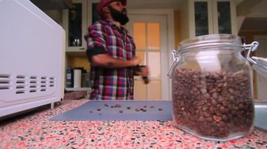 Mutfakta kahve çekirdeklerini elle öğüten biri var.