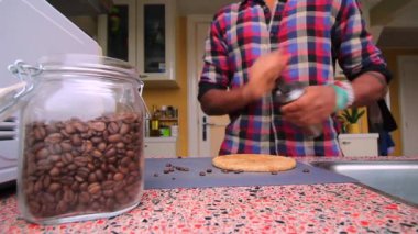 Mutfakta kahve çekirdeklerini elle öğüten biri var.