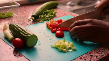 Erkek elleri ahşap kesim tahtasında sebze hazırlıyor.