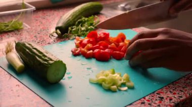 Erkek elleri ahşap kesim tahtasında sebze hazırlıyor.