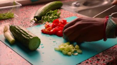 Erkek elleri ahşap kesim tahtasında sebze hazırlıyor.