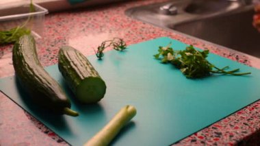 Adam elleriyle mutfakta sebze hazırlıyor.