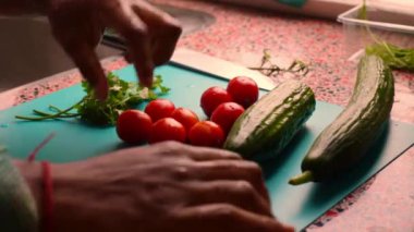 Adam elleriyle mutfakta sebze hazırlıyor.