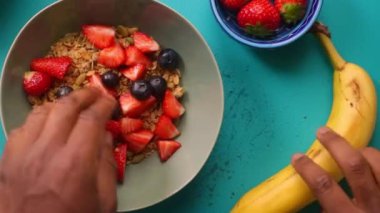 Sağlıklı müsli gevreğini meyvelerle hazırlayan kişinin düz bir görüntüsü vardı.