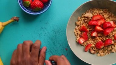 Sağlıklı müsli gevreğini meyvelerle hazırlayan kişinin düz bir görüntüsü vardı.