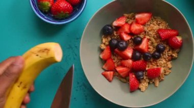 Sağlıklı müsli gevreğini meyvelerle hazırlayan kişinin düz bir görüntüsü vardı.