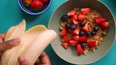 Sağlıklı müsli gevreğini meyvelerle hazırlayan kişinin düz bir görüntüsü vardı.