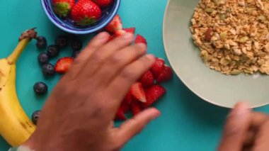 Sağlıklı müsli gevreğini meyvelerle hazırlayan kişinin düz bir görüntüsü vardı.