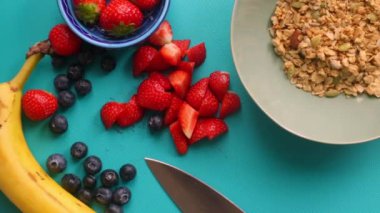 Sağlıklı müsli gevreğini meyvelerle hazırlayan kişinin düz bir görüntüsü vardı.
