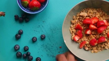 Sağlıklı müsli gevreğini meyvelerle hazırlayan kişinin düz bir görüntüsü vardı.