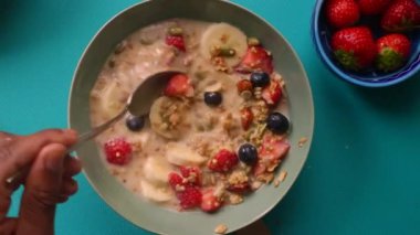 Sağlıklı müsli gevreğini meyvelerle hazırlayan kişinin düz bir görüntüsü vardı.