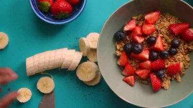 Düz manzaralı biri sağlıklı müsli gevreğini meyvelerle hazırlıyor.