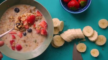Düz manzaralı biri sağlıklı müsli gevreğini meyvelerle hazırlıyor.