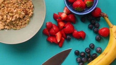 Düz manzaralı biri sağlıklı müsli gevreğini meyvelerle hazırlıyor.