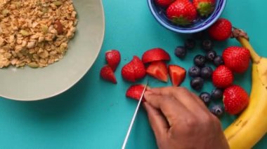 Düz manzaralı biri sağlıklı müsli gevreğini meyvelerle hazırlıyor.
