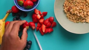 Düz manzaralı biri sağlıklı müsli gevreğini meyvelerle hazırlıyor.