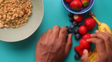 Elleri ahşap kesim tahtasında meyve hazırlıyor.