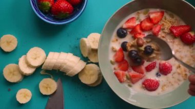 Müsli gevreğini meyvelerle hazırlayan kişinin düz bir görüntüsü vardı.