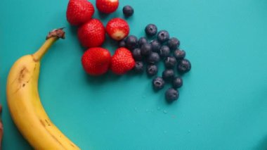 Elleri ahşap kesim tahtasında meyve hazırlıyor.