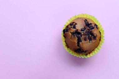 Çikolatalı kek pembe arka planda yatıyor.