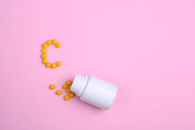 Vitaminler pembe bir zemin üzerine dağılmış, tıpkı mektuptaki gibi. 