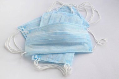 Açık arkaplandaki virüsleri durdurmak için tek kullanımlık mavi yüz maskeleri