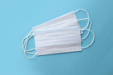 Tıbbi maske, mavi arka planda tıbbi koruyucu maskeler. Coronovirus Covid-19 koruyucu. Tek kullanımlık yüz maskesi ağız ve burnu kapatır. Sağlık ve tıbbi konsept. Sars-cov-2 virüsünü durdurun.