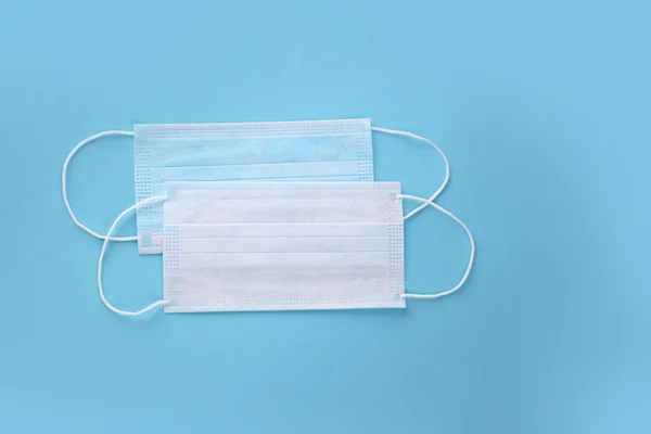 Tıbbi maske, mavi arka planda tıbbi koruyucu maskeler. Coronovirus Covid-19 koruyucu. Tek kullanımlık yüz maskesi ağız ve burnu kapatır. Sağlık ve tıbbi konsept. Sars-cov-2 virüsünü durdurun.