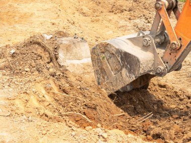 Makineler, inşaat yolundaki elektrik direğini yakmak için zemin kazıyor..