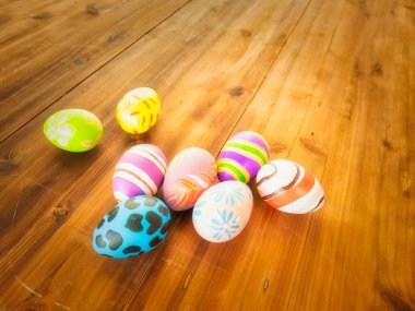 Paskalya yumurtaları çeşitli tasarım ve renklerde ahşap bir arka plana yerleştirilir ve Paskalya 'da sonbahar için kopya alanı yerleştirilir..