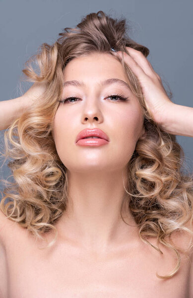 Beautiful girl with curly blond hair and flawless skin