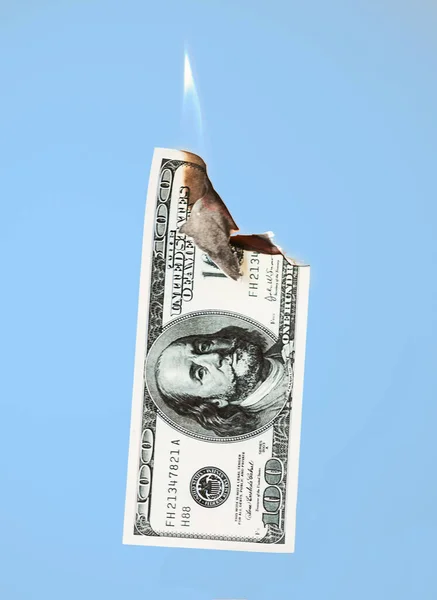 Queima cem dólares em dinheiro no fundo azul — Fotografia de Stock