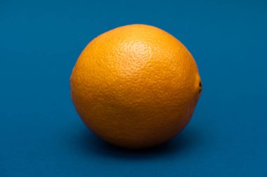 Mavi arka planda uzanan turuncu turunçgil.