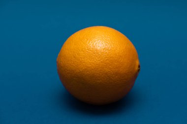 Mavi arka planda uzanan turuncu turunçgil.