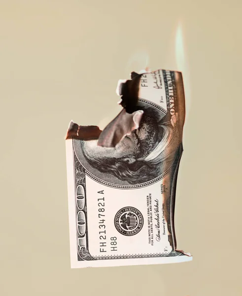 Burning hundred dollars cash on peach background — Stock Photo, Image