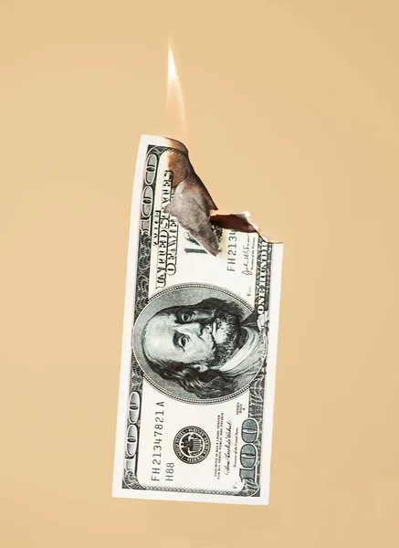 Burning hundred dollars cash on peach background — Stock Photo, Image