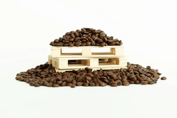 Coffee beans lying on on small wooden pallets — Stock Photo, Image