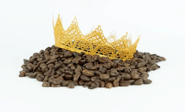 Coffee beans with golden crown lying on white isolated background — Stock Photo, Image