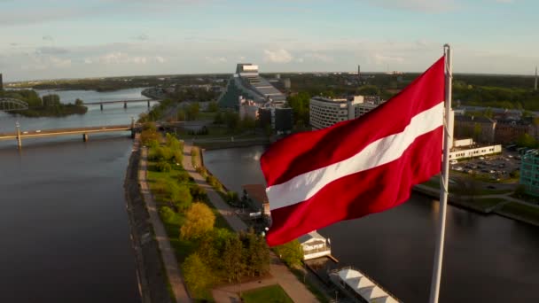 Łotewska flaga machająca na wietrze z rygowym miastem — Wideo stockowe