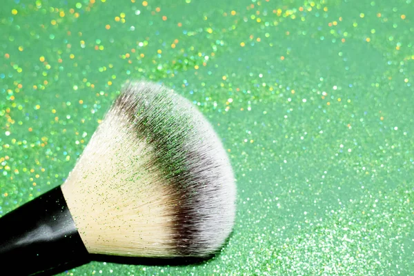 Powder brush with green shimmer shadows