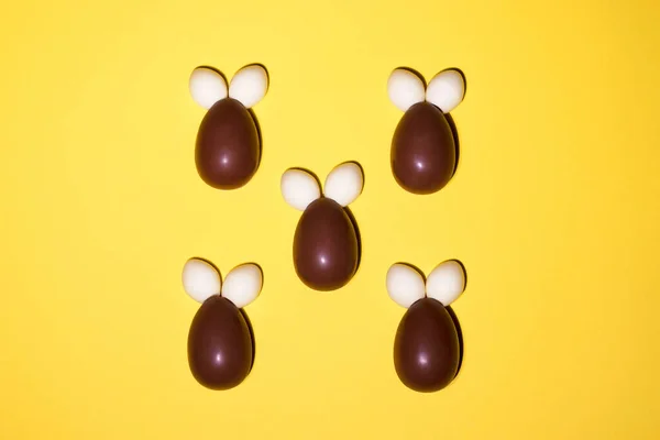 Sarı arka planda çikolata ve jöleden yapılmış tavşanlar. — Stok fotoğraf