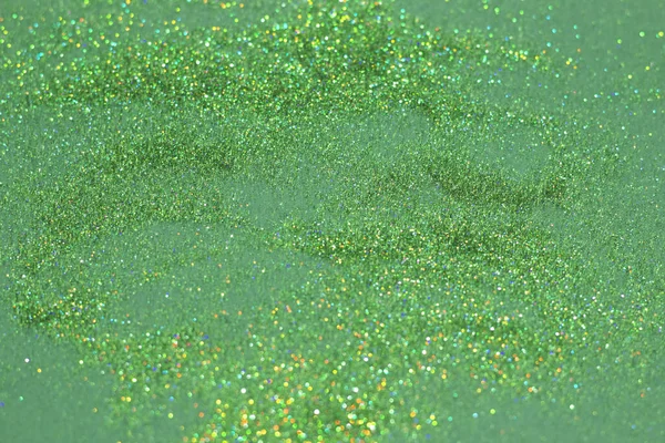 The green sparkles and glitter on a deep green background