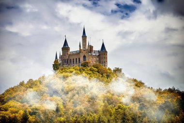 Ormanlık bir dağdaki şato bulutların altında, Hohenzollern, Almanya