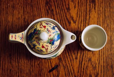 Oryantal çaydanlık, tahta bir masada fincanların yanında.