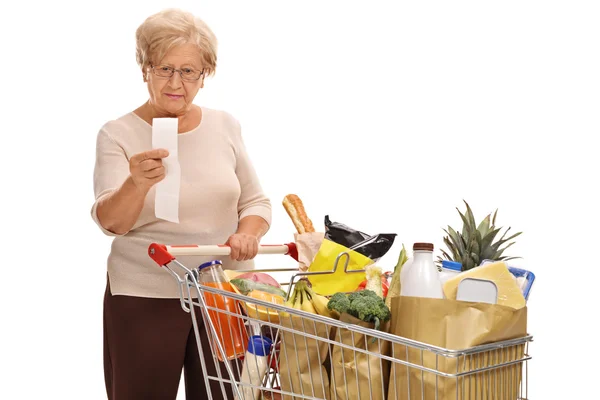 Donna matura guardando una ricevuta del negozio — Foto Stock