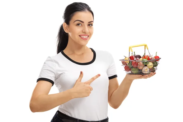 Vrouw houden een klein mandje en wijzen — Stockfoto