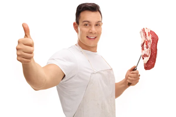 Carnicero dando el pulgar hacia arriba y sosteniendo tenedor con filete — Foto de Stock